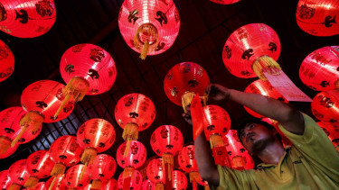 Pekerja memasang kertas nama pada lampion di Vihara Dharma Bhakti, Petak Sembilan, Jakarta, Senin, 28 Januari 2019.