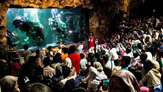 Pengunjung menyaksikan pertunjukan barongsai di dalam air di Seaworld Ancol, Jakarta, Minggu, 3 Februari 2019.