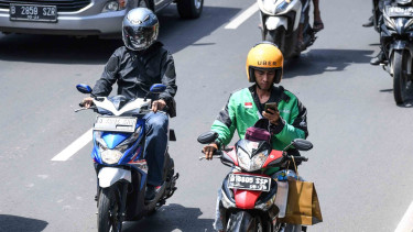 Pengendara sepeda motor mengamati aplikasi GPS (pelacak jalan) di gawainya saat berkendara di Jalan Rasuna Said, Kuningan, Jakarta, Kamis, 7 Februari 2019.