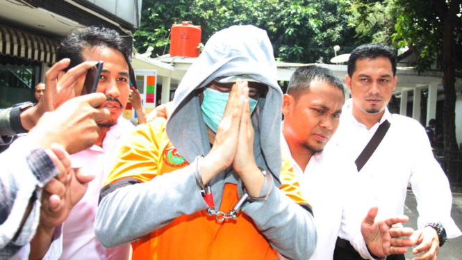 Polisi mengawal pesinetron tersangka kasus narkoba Jupiter Fortissimo (tengah) untuk menjalani pemeriksaan di Dit Narkotika, Polda Metro Jaya, Jakarta