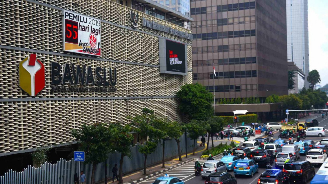 Pengguna jalan melintasi papan hitung mundur elektronik Pemilu 2019 di kantor Bawaslu, Jakarta, Kamis, 21 Februari 2019.