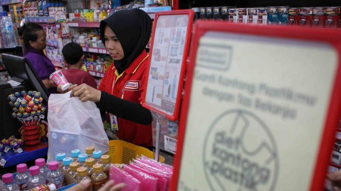 Pramuniaga memasukkan barang yang telah dibeli konsumen ke dalam kantong plastik di salah satu mini market. (ilustrasi)