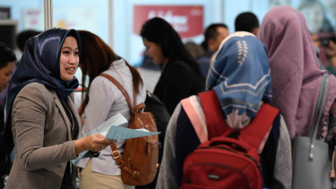 Petugas memberikan brosur informasi lowongan pekerjaan pada Indonesia Spectacular Job Fair “JOB FOR CAREER” Festival 2019 di kawasan Stadion Utama Gelora Bung Karno, Jakarta