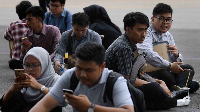 Para pencari kerja beristirahat disela-sela acara Indonesia Spectacular Job Fair “JOB FOR CAREER” Festival 2019 di kawasan Stadion Utama Gelora Bung Karno, Jakarta