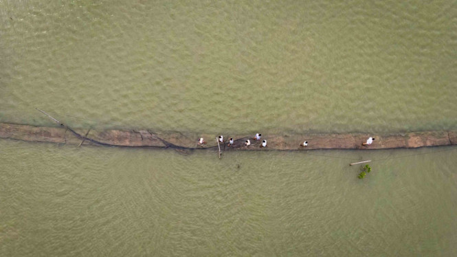Warga menembus jalan desa yang terendam air laut akibat abrasi di Desa Timbulsloko, Sayung, Demak, Jawa Tengah, Kamis, 14 Maret 2019.