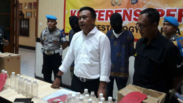 Polisi memperlihatkan dua orang penjual minuman keras jenis ciu yang menewaskan enam orang di Yogyakarta, Selasa, 19 Maret 2019.