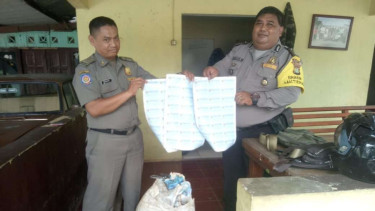Polisi dan aparat kelurahan memperlihatkan lembaran lapisan blanko e-KTP temuan warga di kawasan Harjamukti, Kecamatan Cimanggis, Depok, Jawa Barat, pada Jumat, 22 Maret 2019.