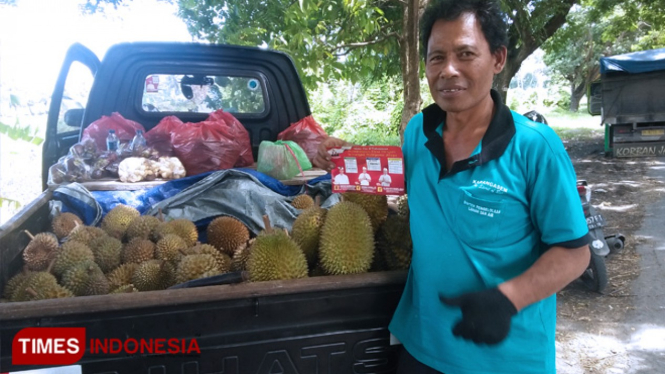 I Wayah Sukrayasa bersama istri dan anak bungsunya saat menjajakan buah durian di Jalan By Pass Ida Bagus Mantra, Kabupaten Gianyar, Bali, Rabu (3/4/2019). (FOTO Khadafi/TIMES Indonesia)