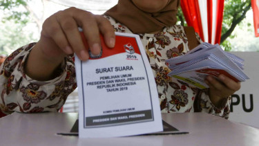Warga memasukan contoh surat suara ke dalam kotak suara usai dicoblos saat simulasi Pemilu serentak 2019.