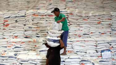 Pekerja mengangkut beras di Gudang Beras Bulog Makassar, Sulawesi Selatan
