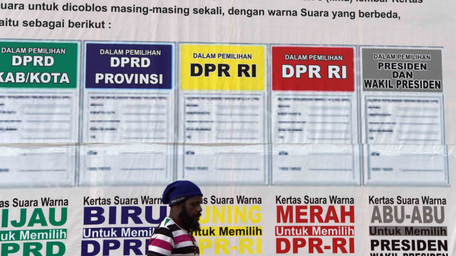 Warga Papua melintas di dekat spanduk sosialisasi Pemilu 2019 yang dipajang di Kantor KPUD Wamena, Jayawijaya. (Foto ilustrasi)