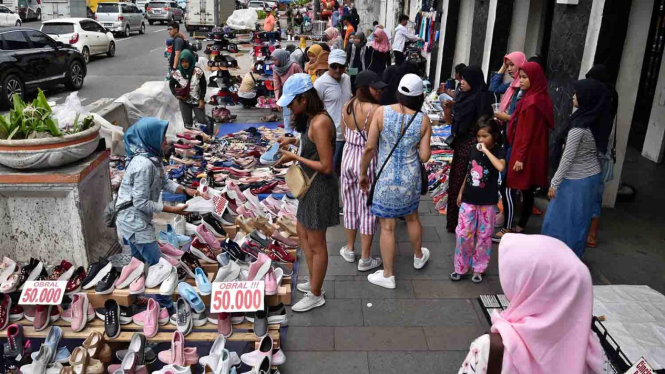Warga berjalan di trotoar yang menjadi lokasi berjualan pedagang kaki lima (PKL) di kawasan Kota Tua, Jakarta, Sabtu, 20 April 2019.