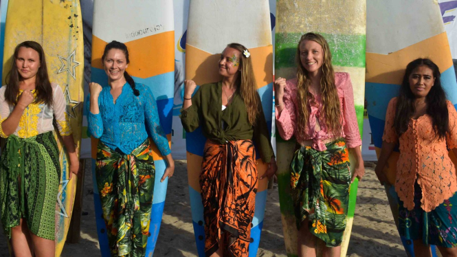 Peselancar wanita yang mengenakan kebaya berfoto sebelum berselancar untuk memeriahkan peringatan Hari Kartini di Pantai Kuta, Bali, Sabtu, 20 April 2019.