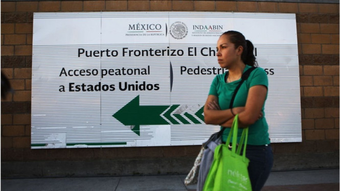 Seorang perempuan berdiri dekat pos perbatasan Amerika Serikat di Tijuana, Meksiko.-Getty Images
