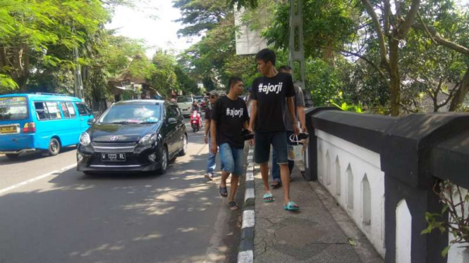 Warga Kota Malang memeriksa cagar budaya Jembatan Kahuripan setelah dicorat-coret oleh kelompok yang diidentifikasi sebagai gerakan Anarko-Sindikalisme saat peringatan Hari Buruh pada Rabu, 1 Mei 2019.