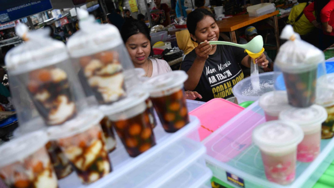 Pedagang membungkus minuman untuk dijual di Pasar Takjil Benhil, Jakarta, Senin, 6 Mei 2019.