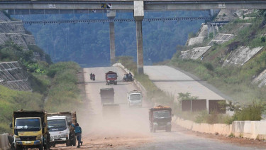 Sejumlah truk melintasi proyek pembangunan Jalan Tol Cileunyi-Sumedang-Dawuan (Cisumdawu) di Kabupaten Sumedang, Jawa Barat, Rabu, 8 Mei 2019.