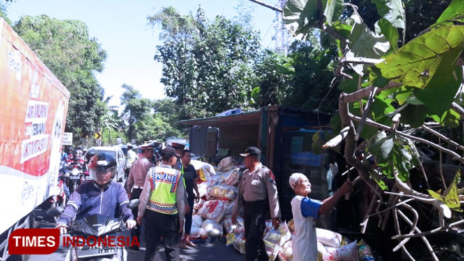 Truk muatan beras terguling di jalan raya Banyuwangi - Jember tepatnya disebelah selatan jembatan Tambong, masuk Desa Pakistaji, Kecamatan Kabat, Banyuwangi. (Foto: Erwin Wahyudi/TIMES Indonesia).