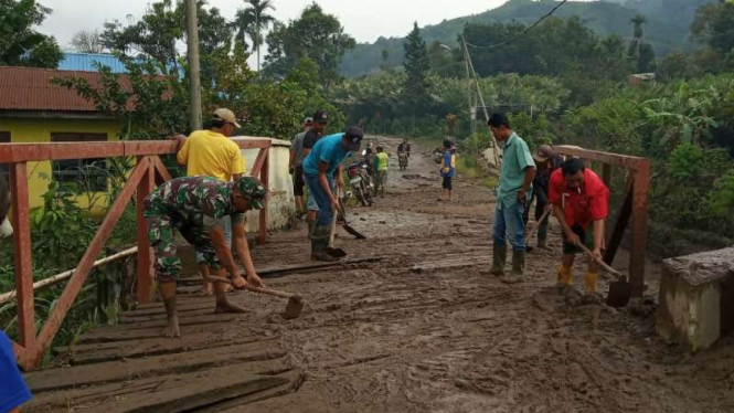 Aparat gabungan bergotong royong membersihkan material lahar dingin dari Gunung Sinabung di sejumlah desa di Kabupaten Karo, Sumatera Utara, Kamis, 11 Juli 2019.