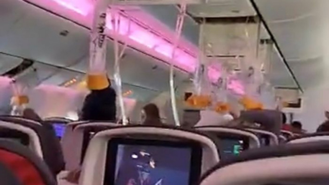 Masker oksigen yang sudah jatuh dari tempatnya dalam pesawat Air Canada.