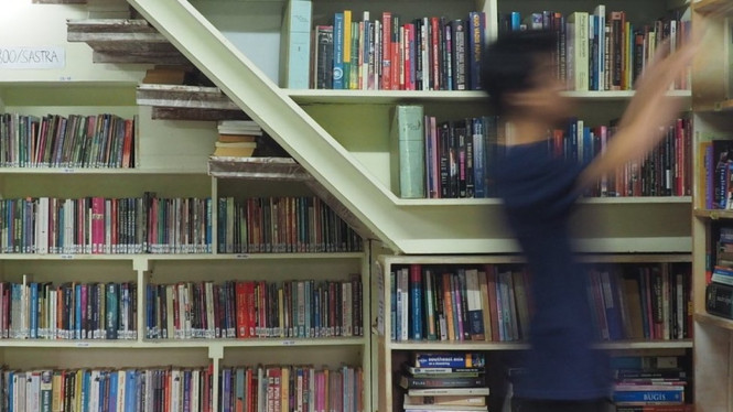 Seorang pengunjung Taman Baca Kesiman di Denpasar, Bali, sedang memilih buku untuk dibaca. - Anton Muhajir