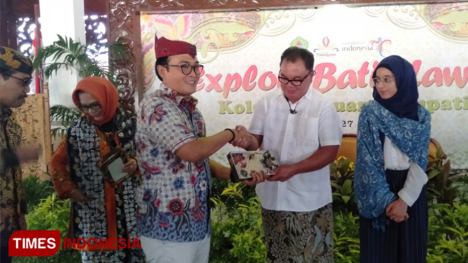 Bupati Pamekasan Badrut Tamam, saat memberikan batik khas Pamekasan pada salah satu tamu undangan dalam acara mengexplore batik lawas di Pandapa Bupati Pamekasan.(Foto: Akhmad Syafi"i/TIMES Indonesia)