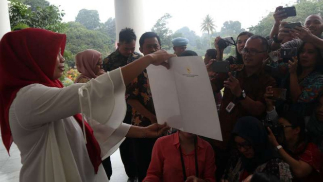 Baiq Nuril menunjukkan Keppres amnestinya kepada wartawan di Istana Bogor