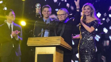 Larry King menggenggam piala