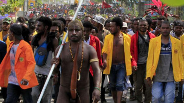 Massa berjalan kaki menuju Kantor Gubernur Papua saat melakukan aksi di Jayapura