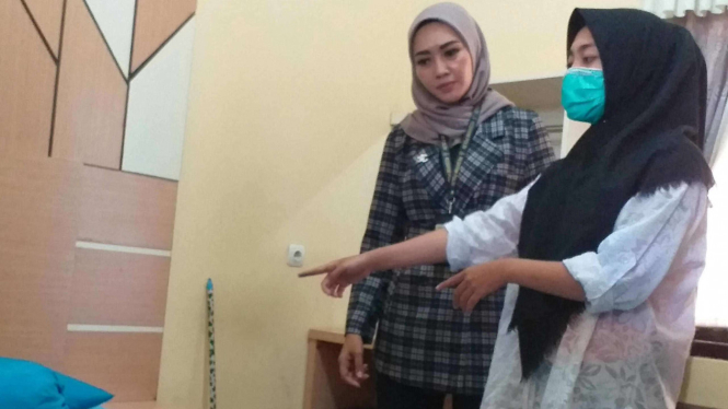 V (19), didampingi tim dari Unit Perlindungan Perempuan Polres Garut, memperlihatkan lokasi adegan video porno gangbang Vina Garut.