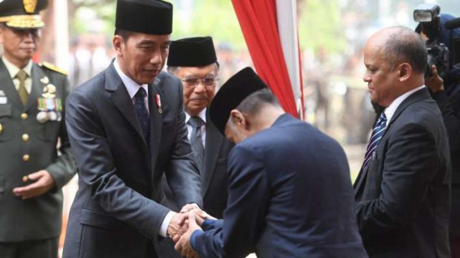 Presiden Joko Widodo (kiri) didampingi Wakil Presiden Jusuf Kalla (kedua kiri) berjabat tangan dengan anak almarhum Presiden ke-3 Republik Indonesia BJ Habibie, Thareq Habibie (kedua kanan) dan Ilham Akbar Habibie (kanan) usai pemakaman BJ Habibie.