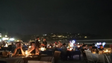 Menikmati seafood di pinggir pantai di Jimbaran, Bali.