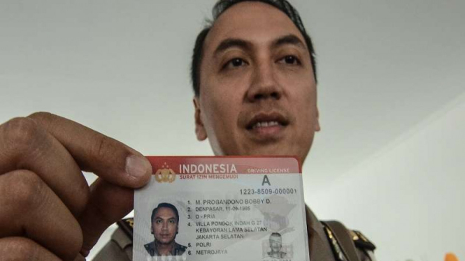 Polisi menunjukkan kartu Smart SIM (Surat Izin Mengemudi)