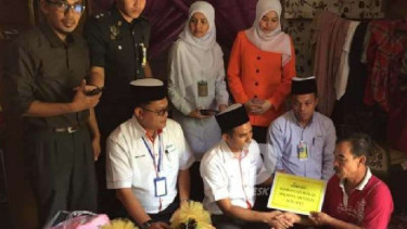 Mohd Zain Abdullah (paling kiri) ketika menerima bantuan.