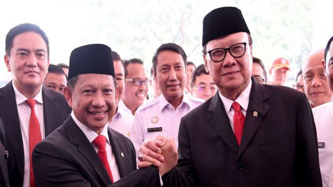 Menteri Dalam Negeri Tito Karnavian (kiri) berjabat tangan dengan pendahulunya, Tjahjo Kumolo.