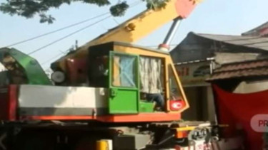 Sebuah alat berat dikerahkan untuk mengevakuasi material tower BTS yang roboh dan menimpa rumah warga di Depok, Jawa Barat, Rabu sore, 6 November 2019.