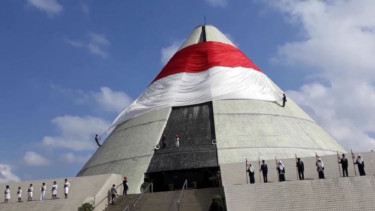 Pengibaran bendera raksasa saat upacara Hari Pahlawan di Monumen Jogja Kembali