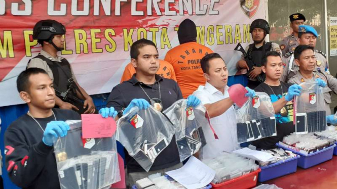 Aparat Polres Kota Tangerang memperlihatkan ponsel-ponsel rekondisi yang disita dari lokasi penggerebekan pabrik rekondisi di Tangerang, Banten, Minggu, 17 November 2019.