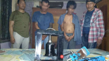 Dua tersangka saat ditangkap aparat di rumah tempat produksi narkoba.