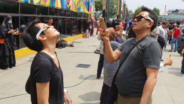 Masyarakat sedang menonton gerhana Matahari di Taman Ismail Marzuki.