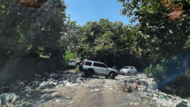 Tumpukan sampah yang meluber hingga keluar jalan TPA Sampah Golo BIlas.