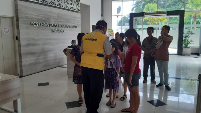 Petugas KKP Entikong mengukur suhu tubuh pelintas batas di PLBN waspadai virus corona.[suarakalbar/Agus]
