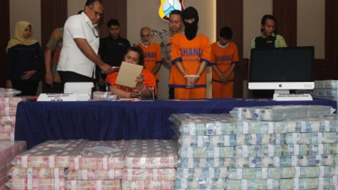 Polisi menghadirkan tersangka dan barang bukti uang saat ungkap kasus investasi ilegal di Polda Jawa Timur, Surabaya, Jawa Timur, Jumat (10/1/2020). Polda Jawa Timur menetapkan empat tersangka atas kasus dugaan investasi ilegal `MeMiles` yang dikelola PT 