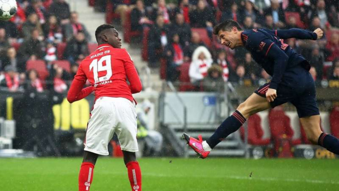 Striker Bayern Munich, Robert Lewandowski (kanan), mencetak gol ke gawang Mainz