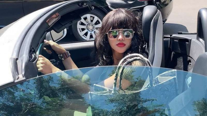 Pose Lucinta Luna di kabin mobil mewah dua pintu.