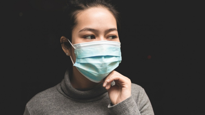Wanita pakai masker.
