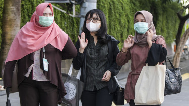 Warga memakai masker sebagai cara mengantisipasi penyebaran virus corona.