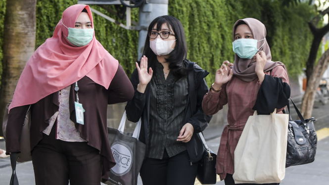 Warga memakai masker sebagai cara mengantisipasi penyebaran virus corona.