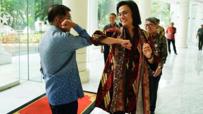 Mantan Wapres Jusuf Kalla dan Menkeu Sri Mulyani melakukan salam corona.