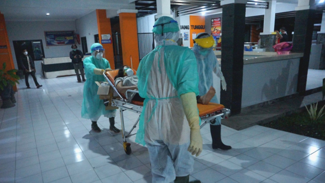 Perawat bawa pasien dalam pengawasan virus corona COVID-19.